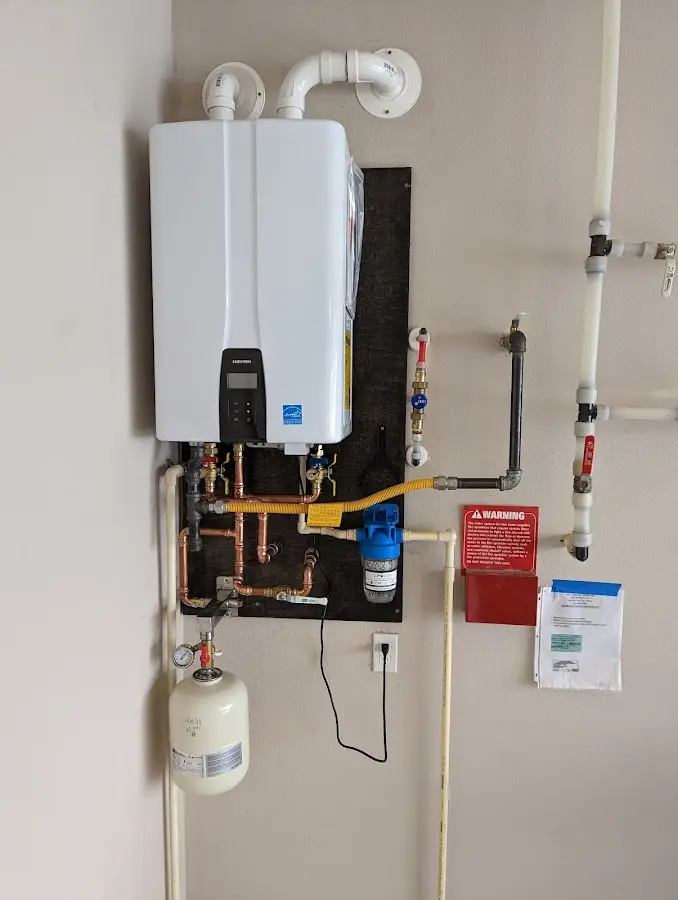 Professional plumber installing copper piping in a Magna home